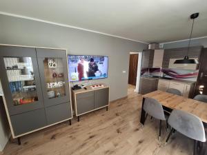 a living room with a dining table and a tv at Apartament Lewin Kłodzki in Lewin Kłodzki
