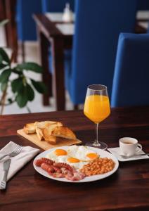 een bord eieren en brood en een glas sinaasappelsap bij König Hotel in Pécs +27 foto's
