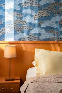 een slaapkamer met een bed en een schilderij van wolken bij König Hotel in Pécs