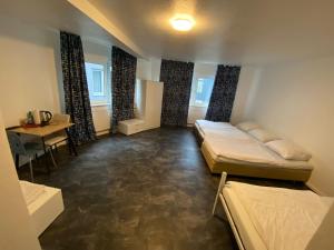 a room with two beds and a table and a desk at Alfa Hotel Frankfurt in Frankfurt