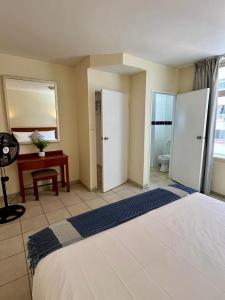 a bedroom with a bed and a desk and a room with at Oceanic Apartment - City and Stadium Views3 - Self-Catering in Durban