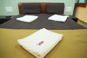 a bed with two white pillows on top of it at Konkantrip Beach Resort in Dapoli