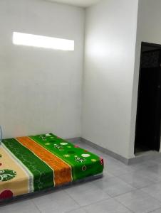 a bed sitting in a corner of a room at Penginapan amalia in Soreang