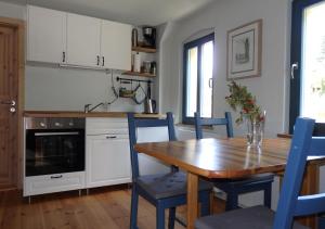 a kitchen with a wooden table and blue chairs at Herberge Landstreicher in Königstein an der Elbe