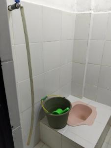 a bathroom with a bucket and a pink toilet at Penginapan amalia in Soreang