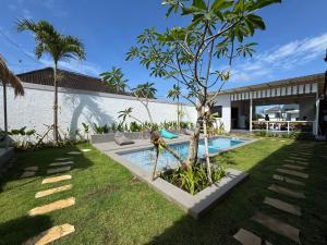 a backyard with a swimming pool and a tree at Wish Uluwatu in Uluwatu