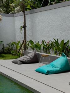a bed with pillows on it next to the water at Wish Uluwatu in Uluwatu