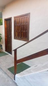 a building with two wooden doors and a staircase at Casa do Carlos Boipeba 2 in Cairu