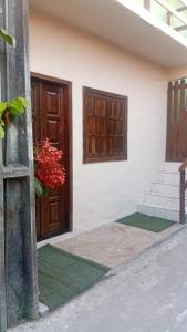 a building with a door and stairs and a red flower at Casa do Carlos Boipeba 2 in Cairu