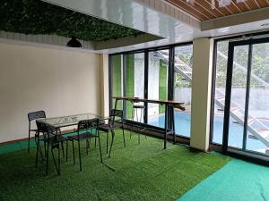 a room with a table and chairs and a pool at Selaras Heritage Villa in Campaka