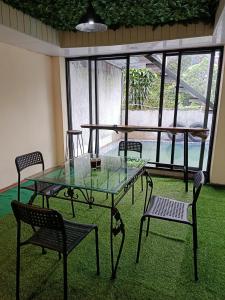 a glass table and chairs in a room with windows at Selaras Heritage Villa in Campaka