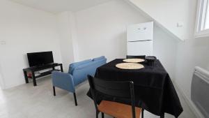 a dining room with a table and two blue chairs at Studio Foch 4 in Grand-Fort-Philippe