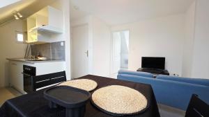 a living room with a blue couch and a table at Studio Foch 4 in Grand-Fort-Philippe
