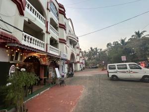 a white van parked in front of a building at Spacious Studio & Pool facility. in Benaulim