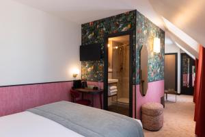 a hotel room with a bed and a bathroom at Hôtel Brittany in Paris +37 photos
