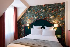 a bedroom with a large bed with a floral wallpaper at Hôtel Brittany in Paris
