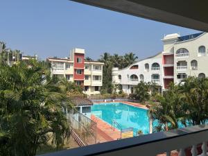 a view from the balcony of a hotel with a swimming pool at Spacious Studio & Pool facility. in Benaulim