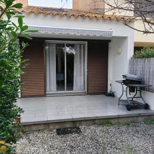 a patio with a grill in front of a house at La casa du creux in Valras-Plage
