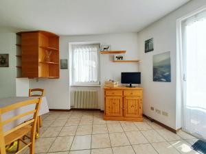 a kitchen with a table and a television in a room at Il Terrazzino Val di Sole in Dimaro +13 photos