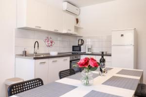 a kitchen with a table with a vase of flowers on it at Villa Feliks in Ljubač