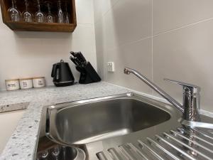 a kitchen sink with a faucet in a kitchen at Downtown, Contemporary and Artistic in Albany +25 photos