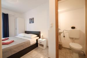 a small bedroom with a bed and a toilet at Villa Feliks in Ljubač