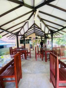 a restaurant with wooden tables and wooden chairs at Green Haven Yala Safari Retreat in Tissamaharama +29 photos