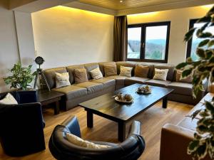 een woonkamer met een bank en een salontafel bij The Great View Sauna & more in Harscheid