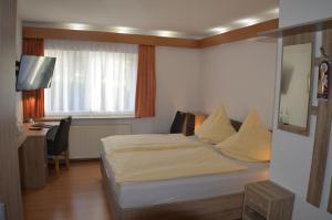 a hotel room with a bed and a desk with a computer at Hotel und Restaurant Feustel in Plauen