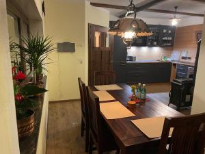 a dining room with a wooden table and a kitchen at Ferienhaus Sprejnik Bautzen in Bautzen