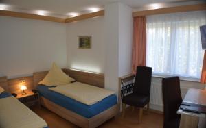 a bedroom with a bed and a desk and a chair at Hotel und Restaurant Feustel in Plauen +5 photos