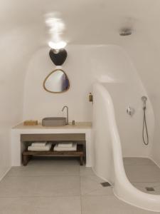 biała łazienka z umywalką i wanną w obiekcie Aspaki by Art Maisons w mieście Oia