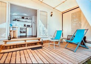 two blue chairs and a table on a deck at safari lodges in Moncarapacho