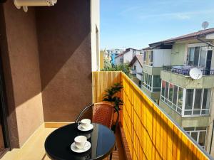 a black table with two cups on a balcony at La Playa Residence in Năvodari +5 photos