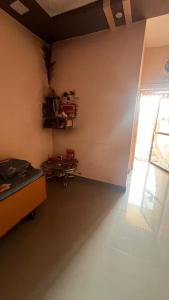 an empty room with a large window and a table at Madhuram Township in Jamnagar