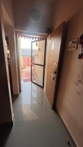 an empty hallway with a door and a window at Madhuram Township in Jamnagar