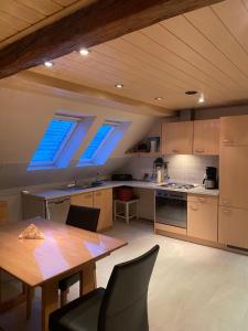 a kitchen with a wooden table and a dining room at Münsterblick in Wolframs-Eschenbach