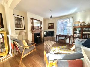 a living room with a couch and a tv at Laurel Cottage in Exmouth