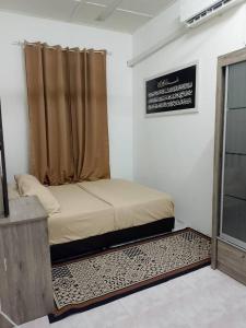 a bedroom with a bed with a curtain and a rug at Tipika Guest House - di Pasir Pekan sempadan 3 Daerah KB, Pasir Mas & Tumpat in Tumpat