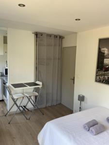 a bedroom with a bed and a table and a kitchen at Studio Saint-Tropez Heraclée in Saint-Tropez