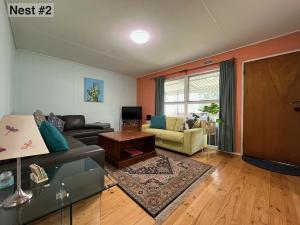 a living room with a couch and a table at Grampians Nest in Halls Gap