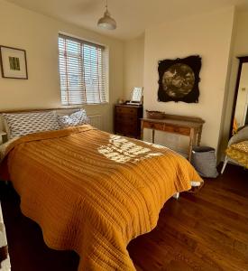 a bedroom with a bed and a table and a window at Laurel Cottage in Exmouth