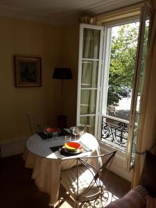 una mesa con un plato de comida junto a una ventana en Sur Le Vieux Port Appartement Vue Sur Mer, en La Rochelle