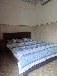 a bedroom with a large bed with blue sheets at Homestay Mỹ Ánh 1 in Phú Quốc