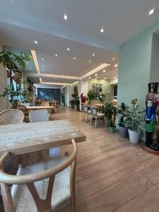 a lobby with a table and chairs and potted plants at The Maroon Bottle Hotel in Thessaloniki