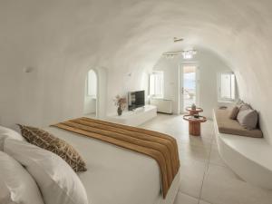a white bedroom with a bed and a living room at Aspaki by Art Maisons in Oia