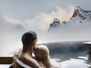 a couple sitting in a bath tub in the mountains at Mondschein Chalet Ski-In Ski-Out in Stuben am Arlberg