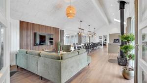 a living room with a couch and a dining room at Villavilla 546 - Hostrup Strand, Limfjorden in Spottrup