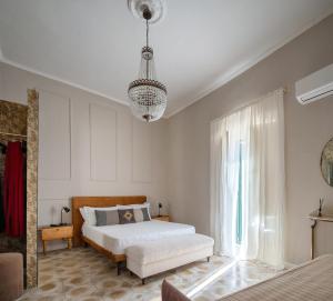 a bedroom with a white bed and a chandelier at Ziolì Apartment in Noto