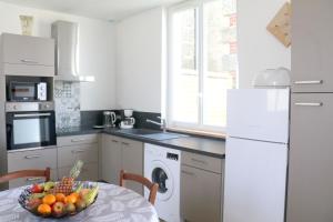 a kitchen with a table with a bowl of fruit on it at Le Logis d'Anaïs in Trémont